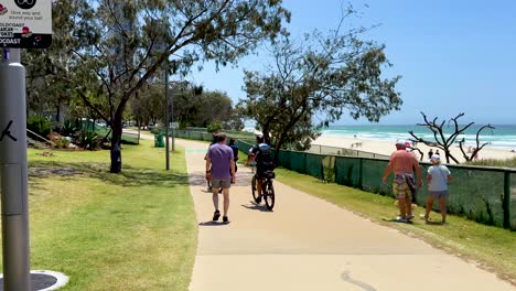 people walking and cycling by the beach