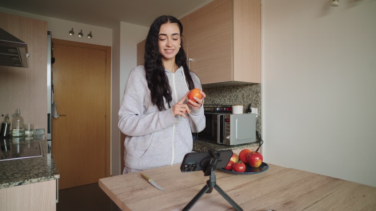 Woman making video about cooking in kitchen