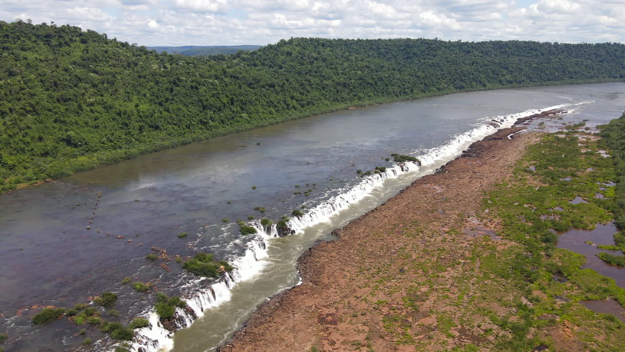 A lateral drone view of Mocon&aacute; Falls on a clear day, showcasing the stunning longitudinal waterfalls