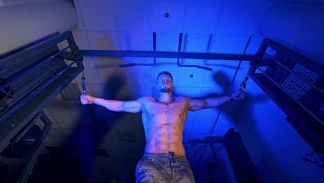 athlete with strong body doing work out pushing up excercise in gym. view from the bottom.