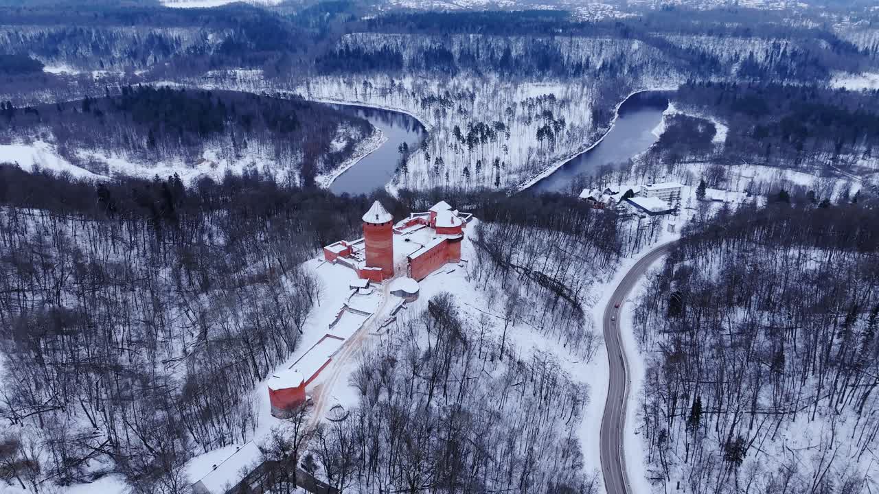 Turaida Castle, winter landscape, snowy trees and the winding Gauja River, drone