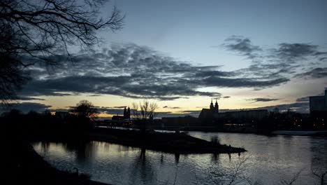 a stunning timelapse of the river elbe in magdeburg, capturing the transition from daylight to darkness as the evening sets in.