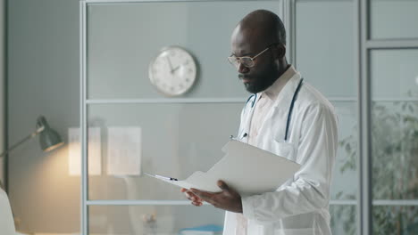 african american doctor working with documents in clinic