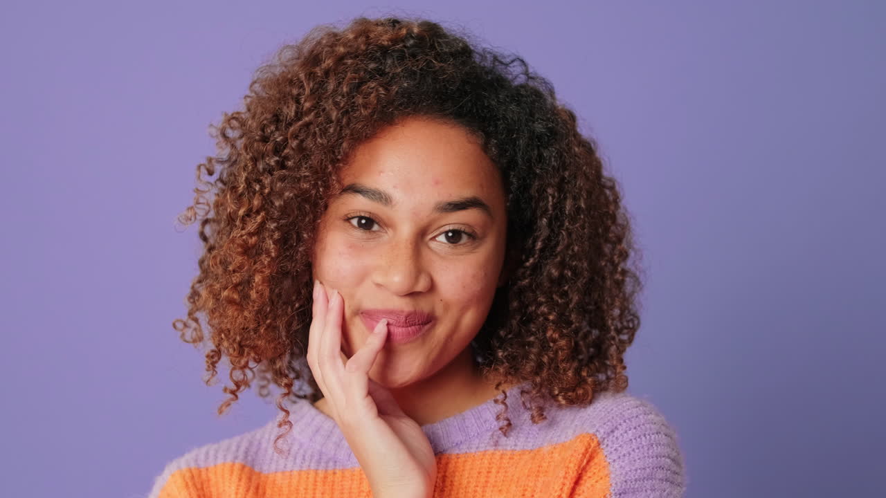 Happy Young Woman with Curly Hair Smiling at Camera