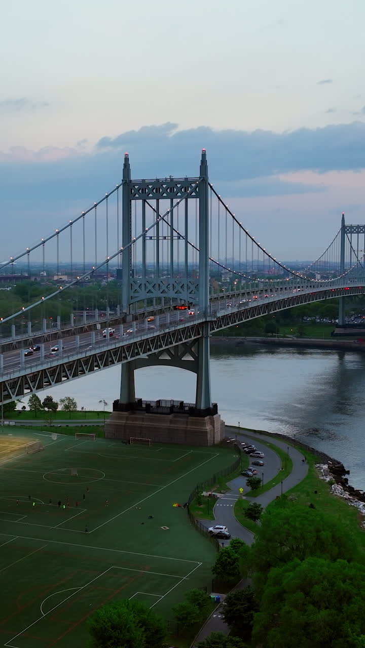 Several football pitches locating under Triborough Bridge in New York. Hell Gate Bridge at backdrop. Vertical video