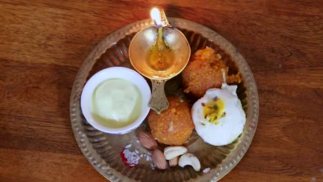 copper plate filled with rakhi sweets and oil lamp on the occasion of raksha bandhan