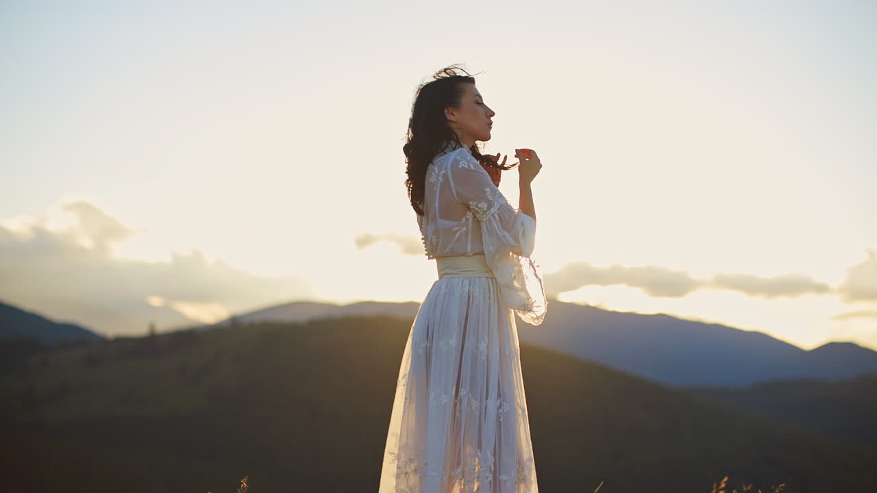Woman in a white dress at sunset in mountains