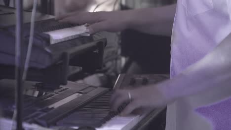 keyboardist plays on several musical instruments at a concert as part of a musical group