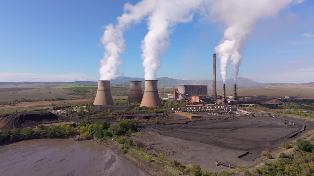 Cooling towers emit steam over rural landscape, Bulgaria