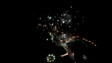 drone view of fireworks bursting above festive plaza at night