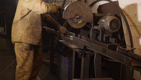 obrero metalúrgico que corta metal con una sierra circular