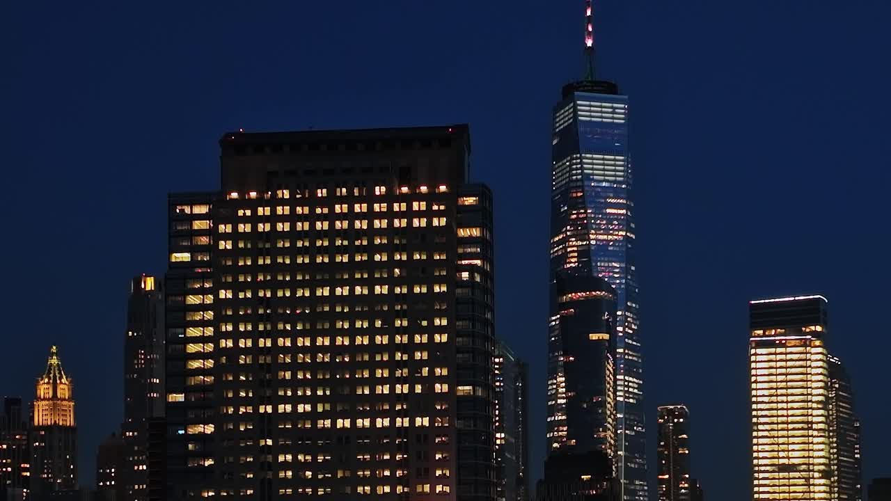 Nighttime aerial view of New York City with illuminated skyscrapers