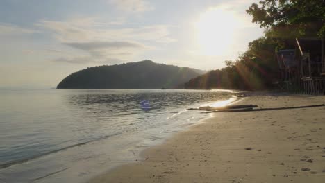 beautiful sandy beach in kri island with small wooden huts, raja ampat archipelago in indonesia