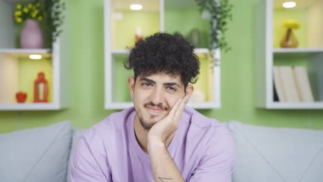 joven mirando a la cámara felizmente.