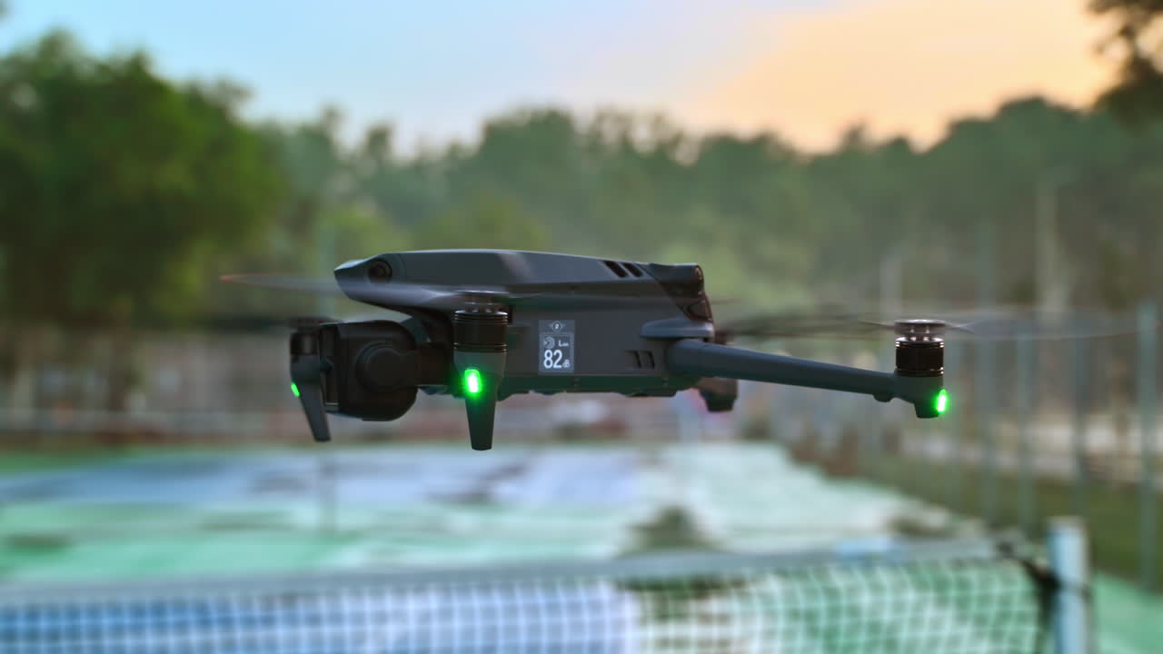 Drone filming a blue and green court at sunrise, after rain