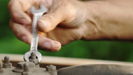 Person repairing a machine with a wrench