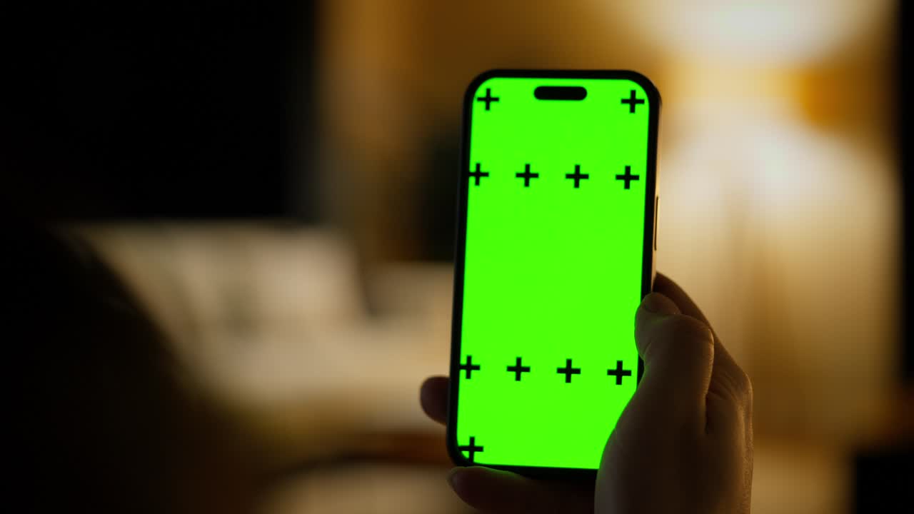 Hand Swiping on Green Screen Smartphone in Dark Room