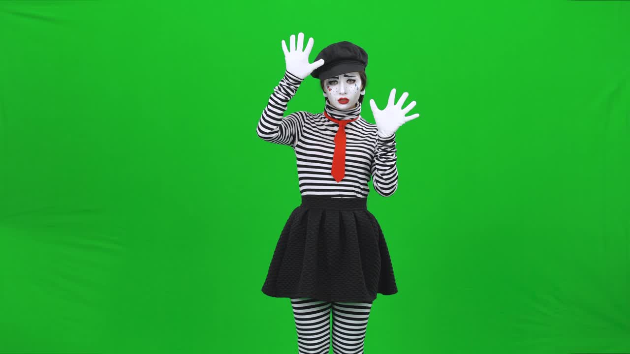 la mujer del mimo está poniendo las manos en el vidrio invisible.