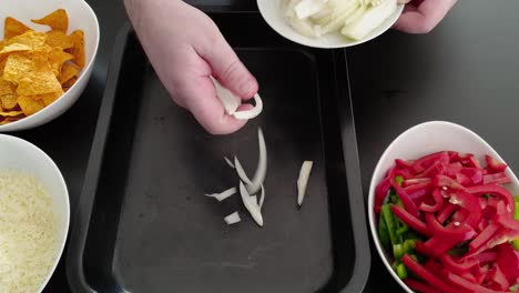 placing sliced white onions in a baking tray