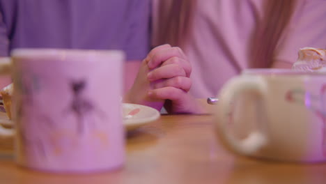 people praying hands at a cafe table