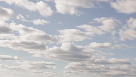 Panning-shot-of-a-bright-blue-cloudy-sky-in-the-summer