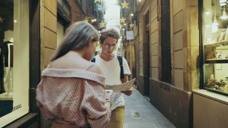 focused student searching way with map. pretty woman showing right way to man.