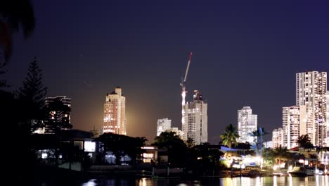 timelapse of moon rising behind city buildings