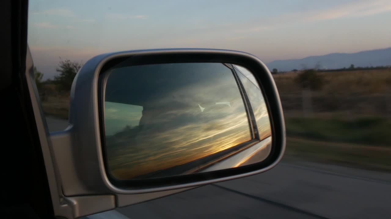 Sunset Reflected In The Right Side Mirror Of A Car