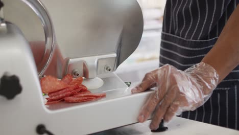 Animation-of-hands-of-biracial-waiter-using-meat-cutting-machine