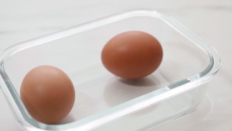 close up male hand taking brown eggs out of the carton