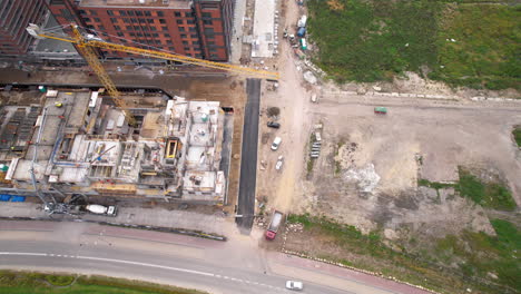 aerial top down shot of construction site with crane and machinery for housing area