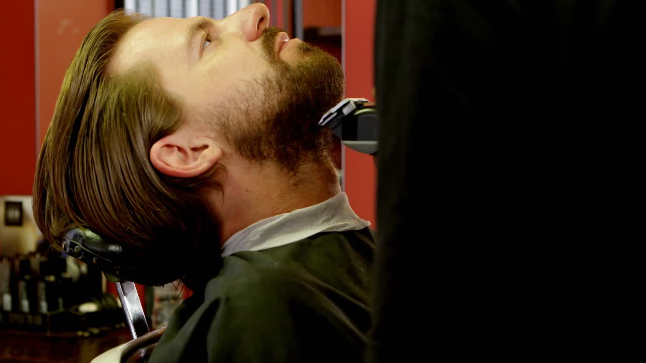 hombre recortando su bigote en el salón de peluquería 4k