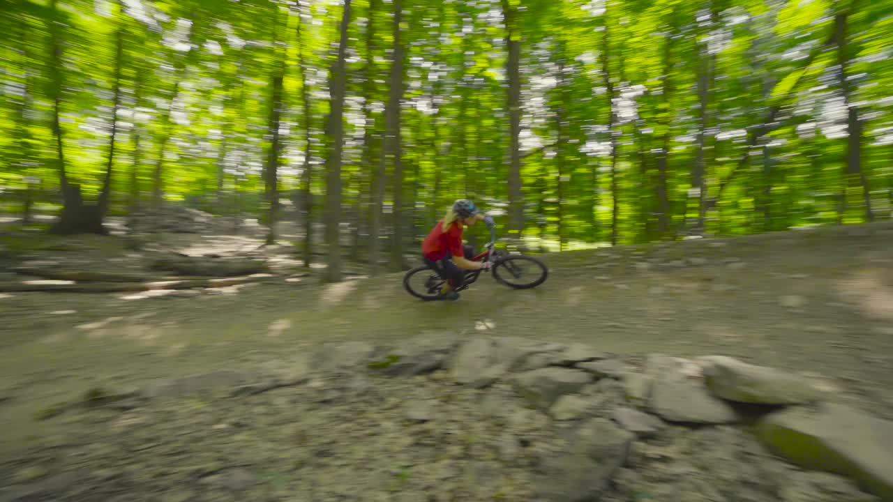 A rider flies through a berm and jumps out and then proceeds to whip the next jump.