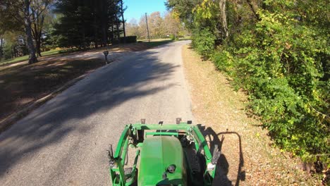 high angle point of view while driving a small green tractor with lift forks on the front