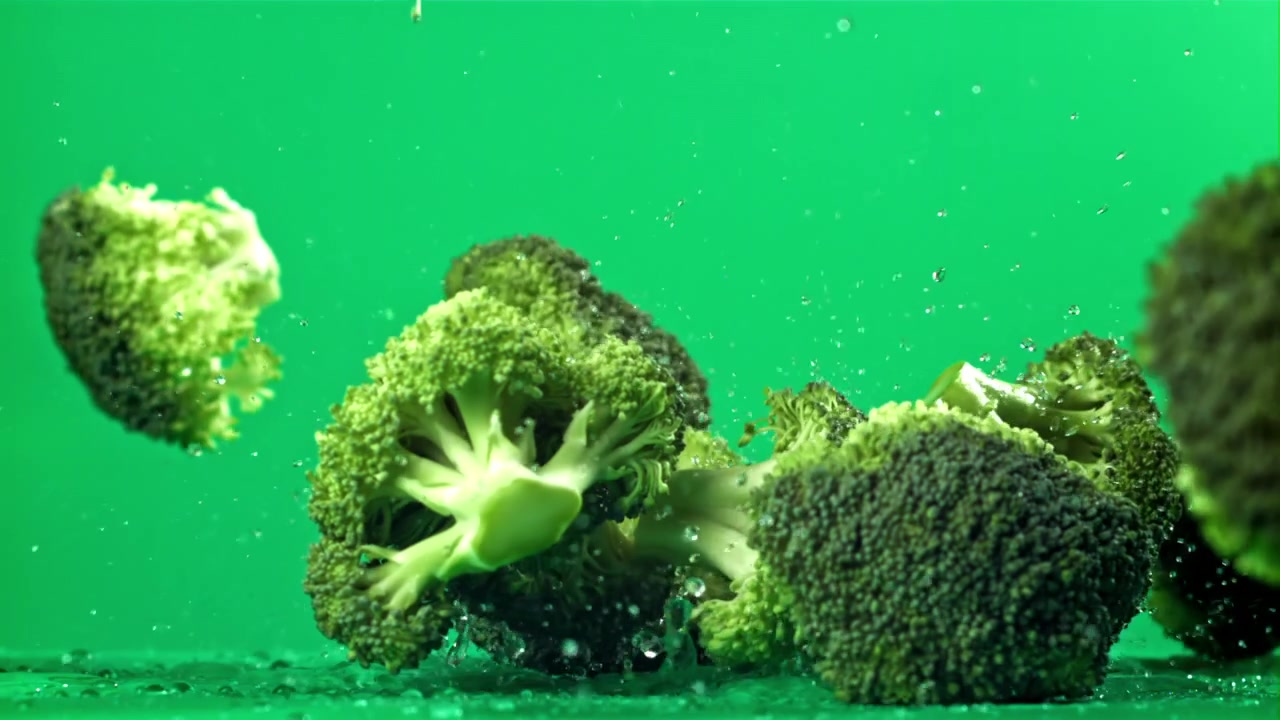 Green Broccoli Florets Falling and Splashing in Slow Motion