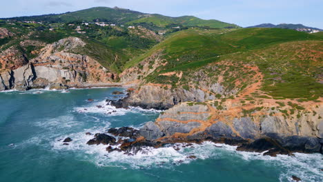 beautiful sunny coastal landscape drone view. ocean splashing rocky shoreline