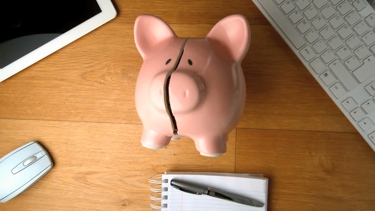 la caja de ahorros cae en un escritorio al lado de la tableta pc y el teclado