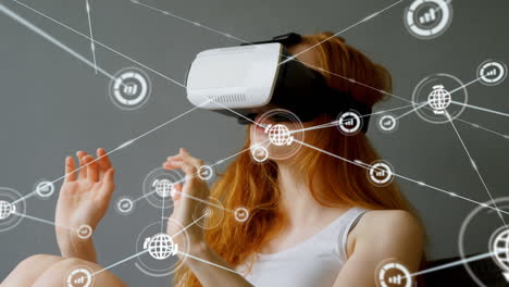 animation of network of connections with icons over woman wearing vr headset