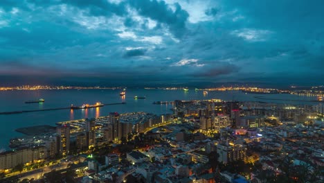 Icónico-Paisaje-Urbano-De-Gibraltar-Con-Puerto-En-El-Fondo,-Luces-Nocturnas,-Lapso-De-Tiempo