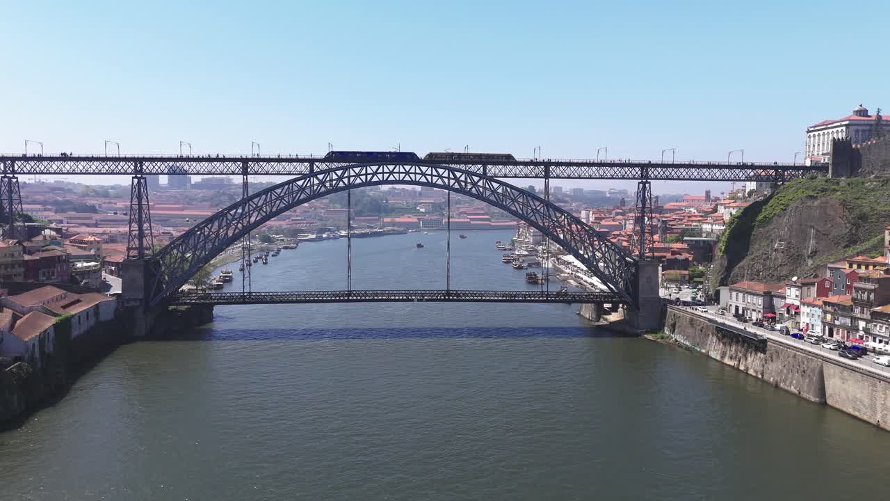 Fly towards Luís I Bridge in Porto, Portugal while train passing by