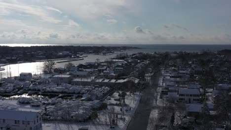 An-aerial-drone-view-over-Bay-Shore,-NY,-on-a-bright-day-after-a-recent-snowfall
