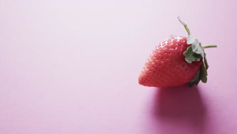 video of strawberry with copy space over pink background