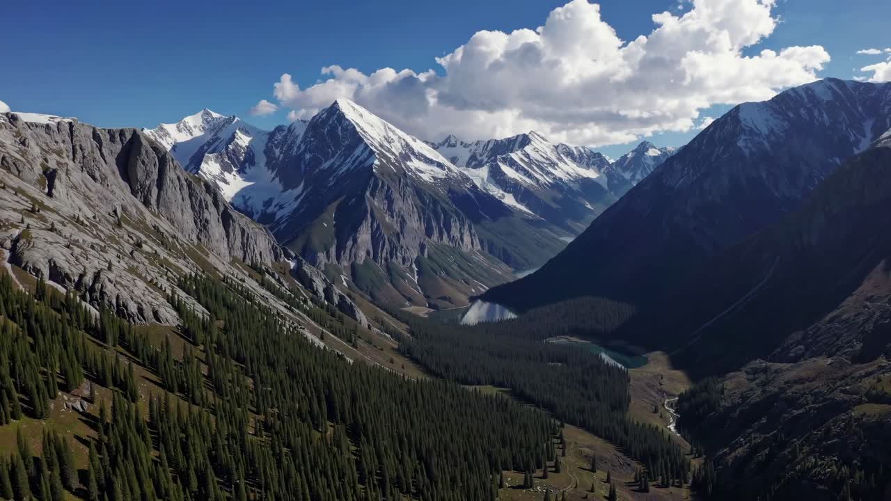 Aerial video of majestic mountains with snow-capped peaks and lush forests