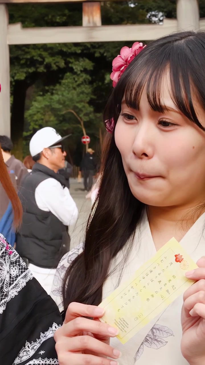 Donne giapponesi in kimono floreali leggono gli omikuji al Santuario Meiji a Tokyo, Giappone