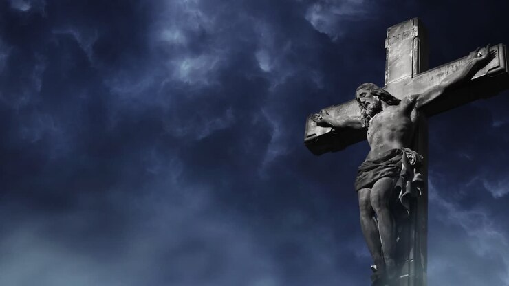 statua di gesù sulla croce su uno sfondo di nuvola scura