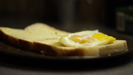 huevos fritos colocados sobre una rebanada de pan blanco, todavía humeantes