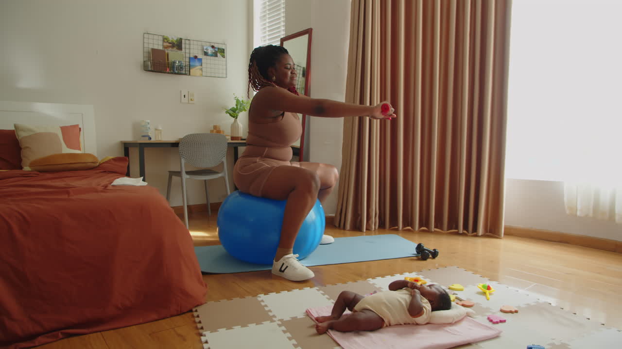 Mãe de recém-nascida se exercitando em bola de ginástica