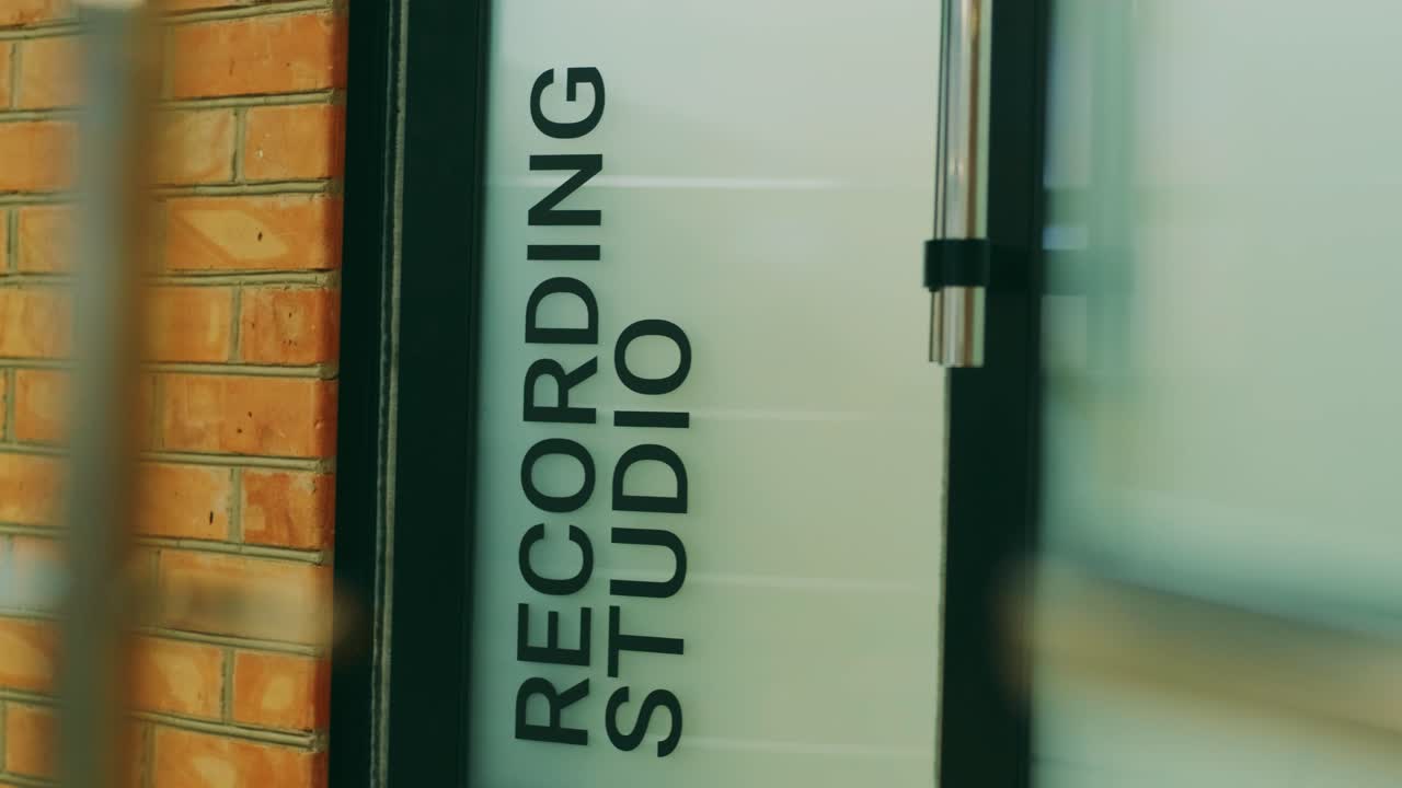 un hombre en vaqueros azules entra en la puerta de los estudios de grabación