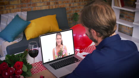 pareja caucásica en una cita de san valentín videollamada mujer sonriente en la pantalla del portátil sosteniendo flores