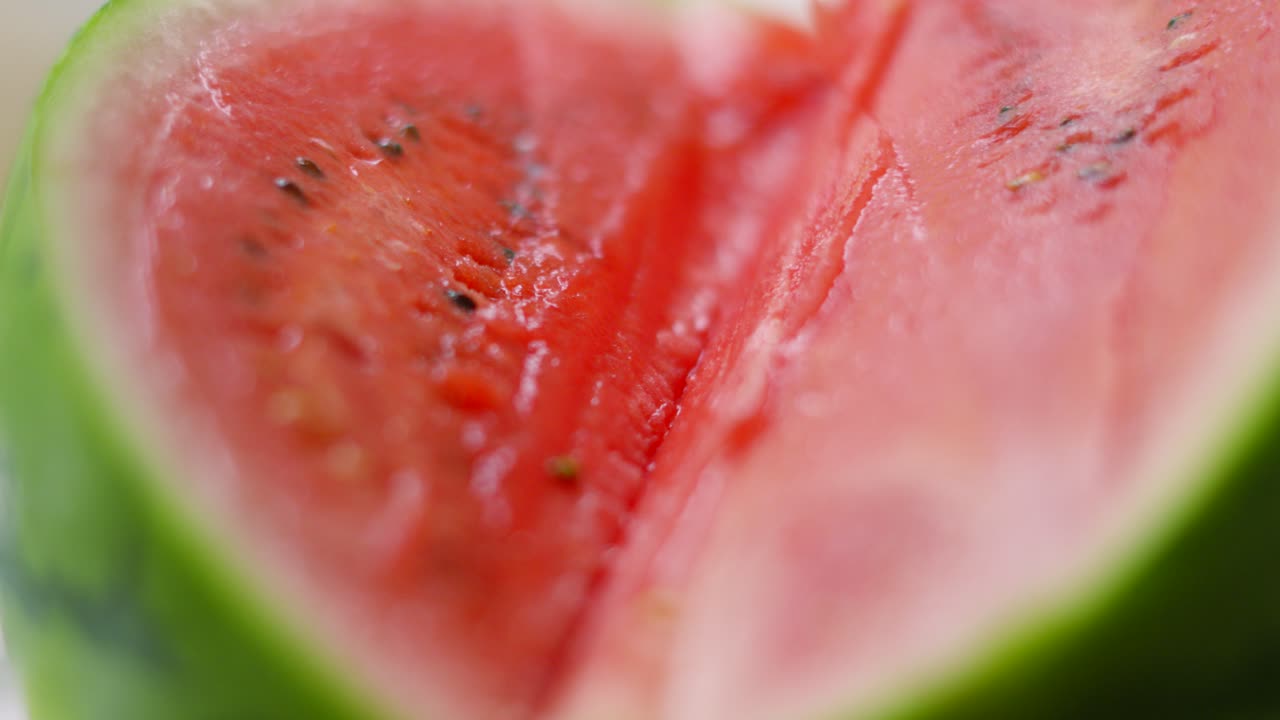 View from Middle of Freshly Sliced Watermelon with Juicy Red Interior with Seeds and Green Skin on Outside. Healthy Vegan Fruit Packed Full of Fibre and Nutrients
